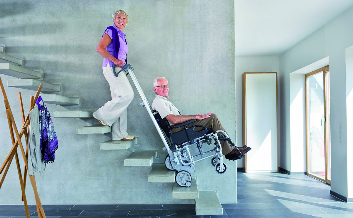 Bild Person die eine person im Scalamobil die Treppe herunter bewegt.